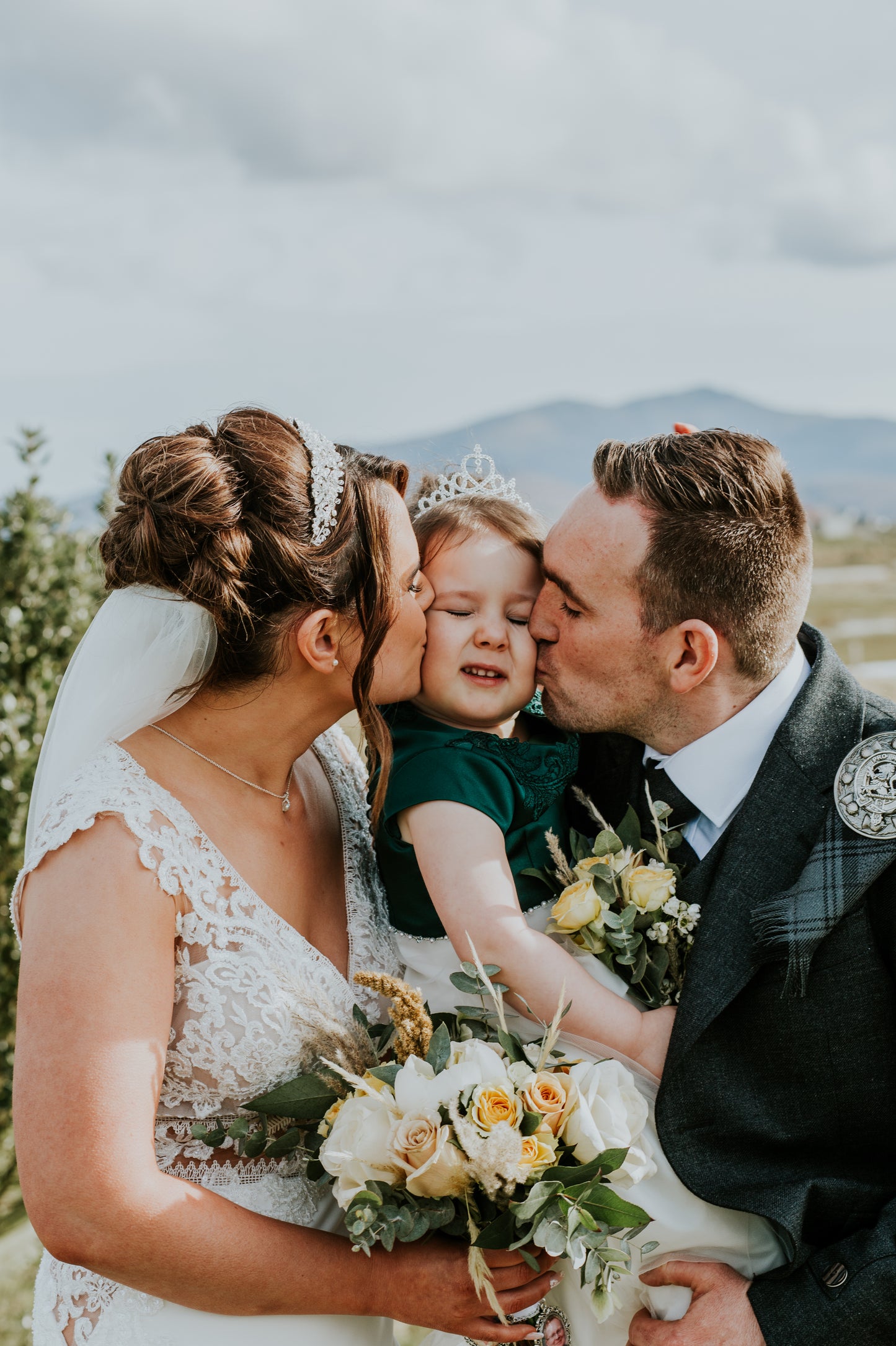 Wedding couple with a child in a scenic outdoor setting