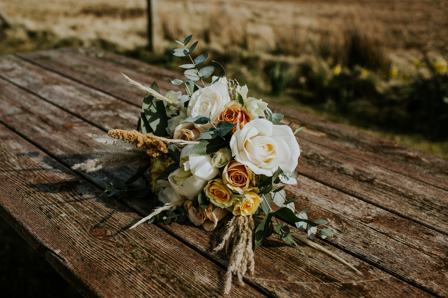 Bouquet of flowers on a wooden surface with a blurred natural background