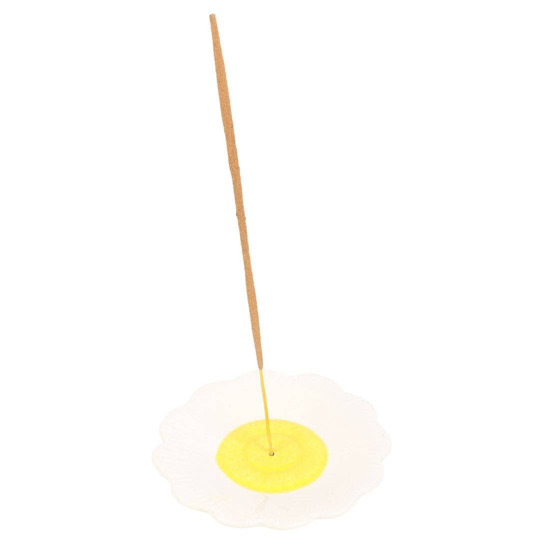 Incense stick on a yellow disc with a white background