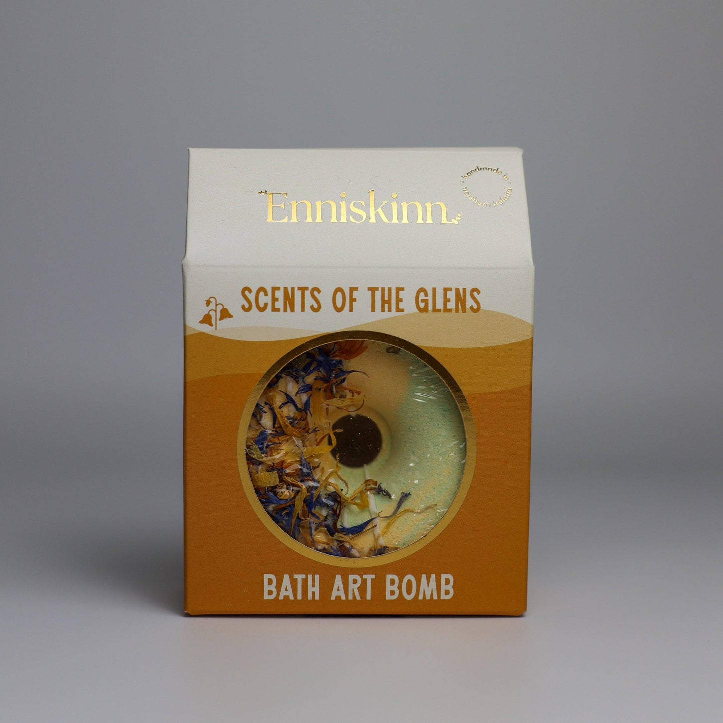 Bath art bomb packaging with 'Enniskinn' branding on a gray background