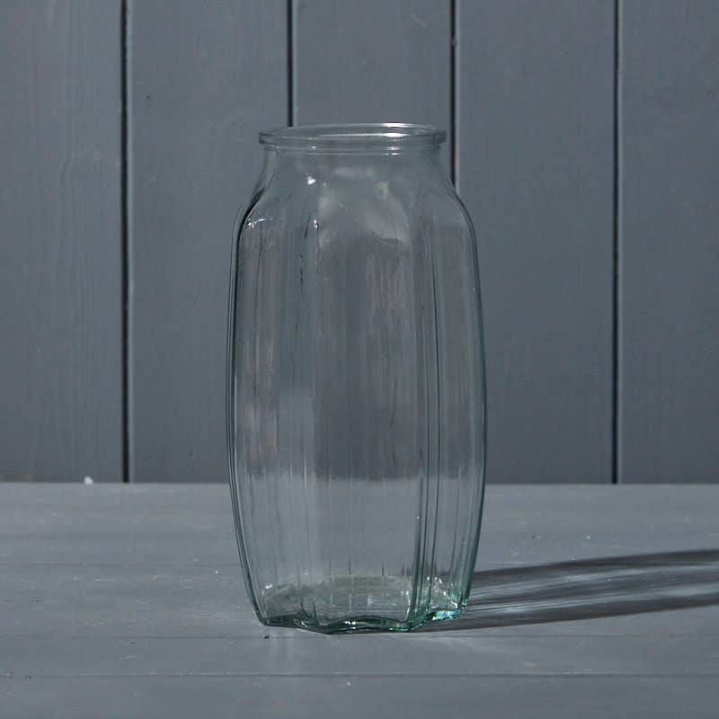 Clear glass vase on a gray surface with a gray background