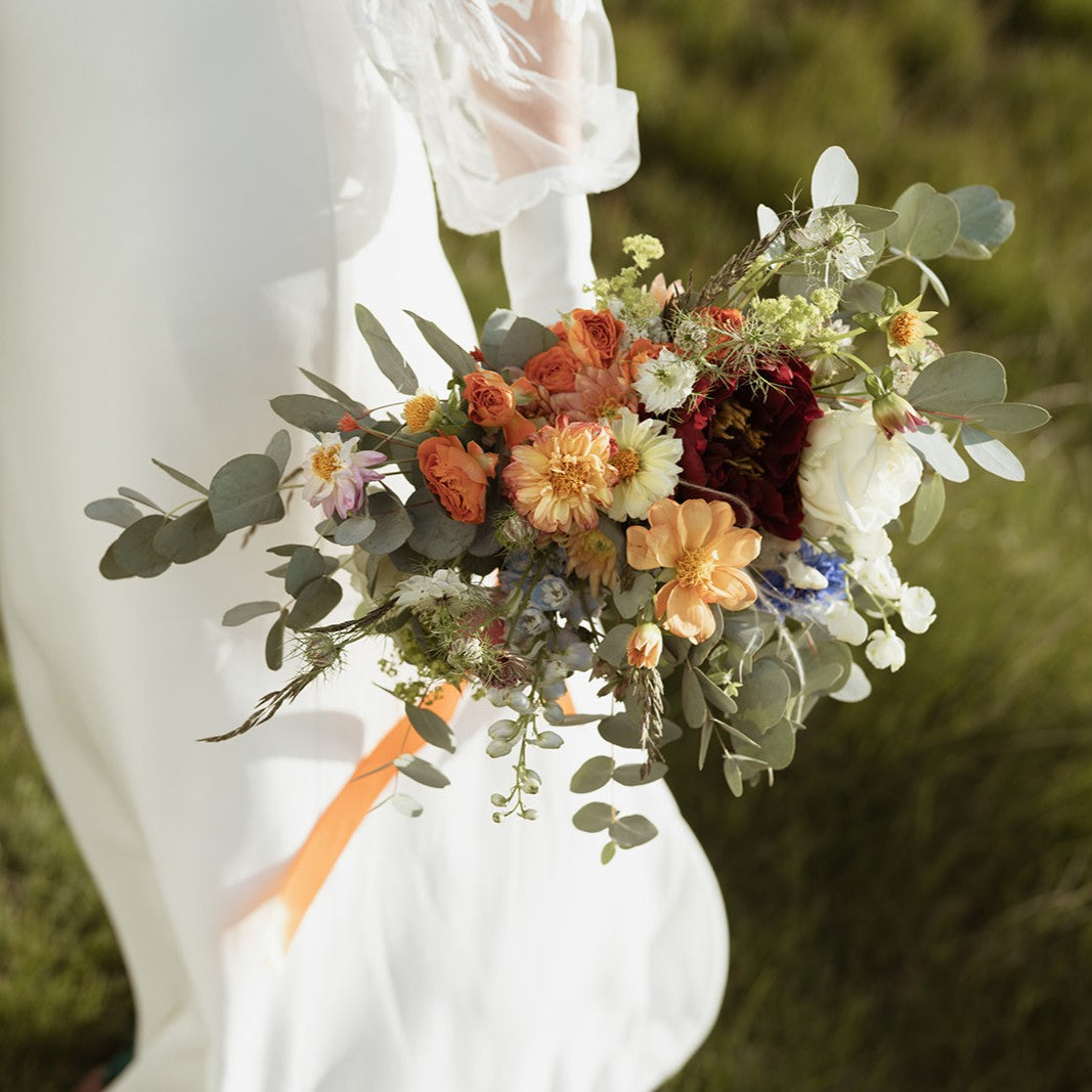 Boho autumnal wedding bouquet held by bride 