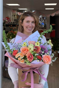 Florist's Choice bouquet featuring peach roses, peach germini, spray roses, snapdragons and seasonal flowers.
