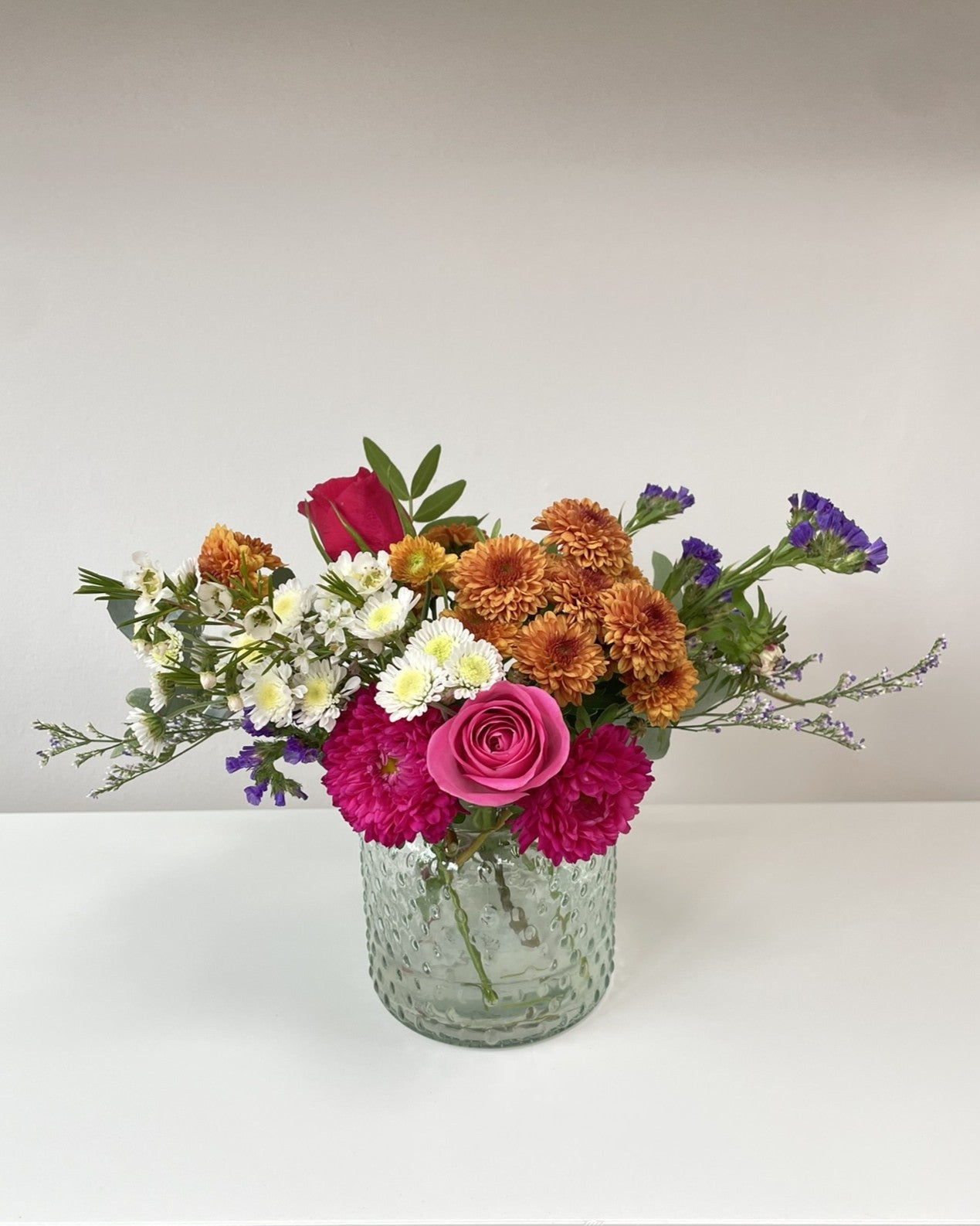 Mini posy of flowers in vase on table