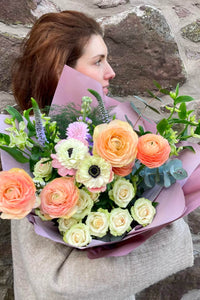 Peaches & Cream spring bouquet with peach ranunculus, cream spray roses and soft seasonal flowers.