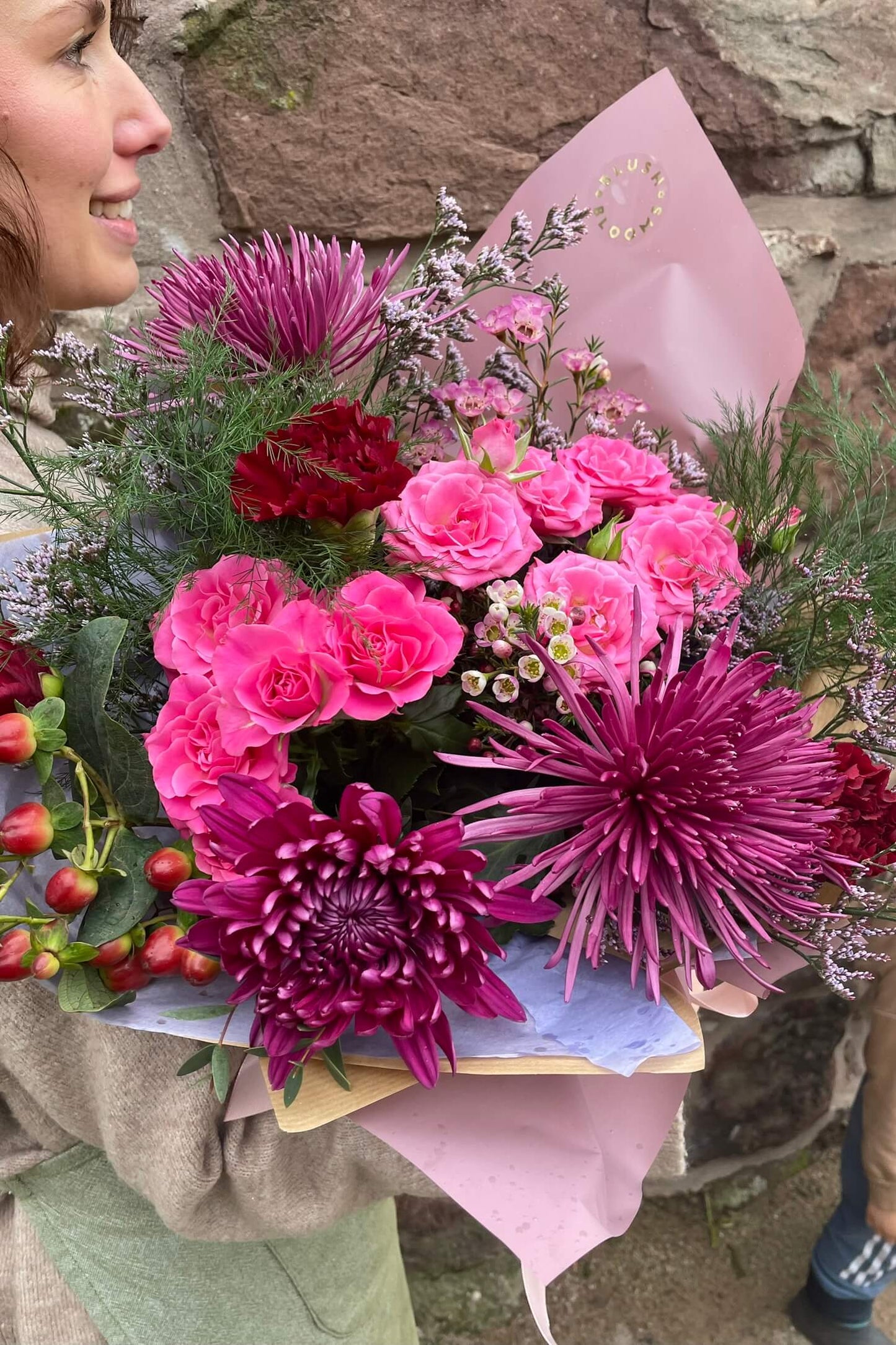Pink Berry spring bouquet with bright pink roses, burgundy chrysanthemums and seasonal foliage by Blush Blooms.