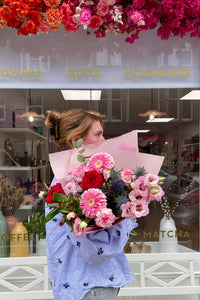 Summer Bloom bouquet featuring red roses, pink chrysanthemums, lisianthus and thistles.