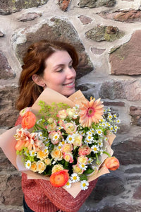Sunset Peach bouquet featuring peach ranunculus, gerbera, tulips and daisies.